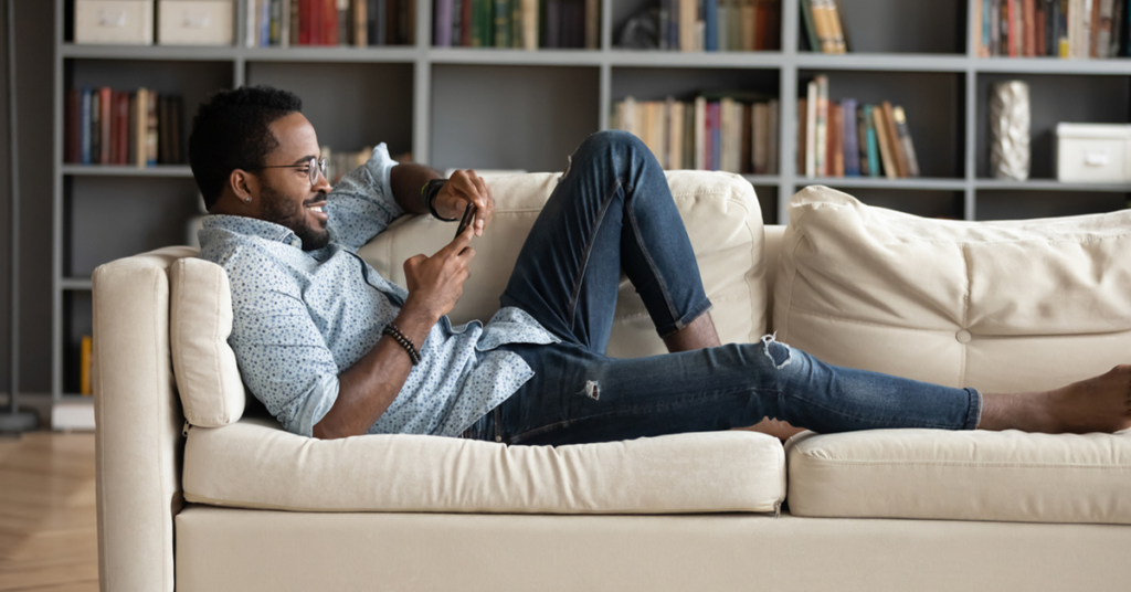 a person sitting in a living room with a book shelf
