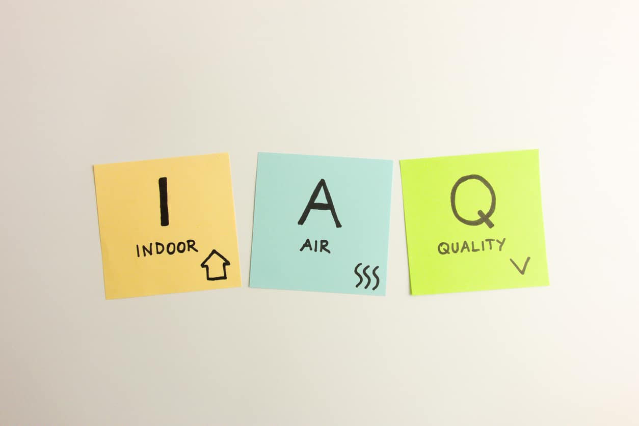 IAQ indoor air quality acronym handwritten on orange, blue, and green sticky notes